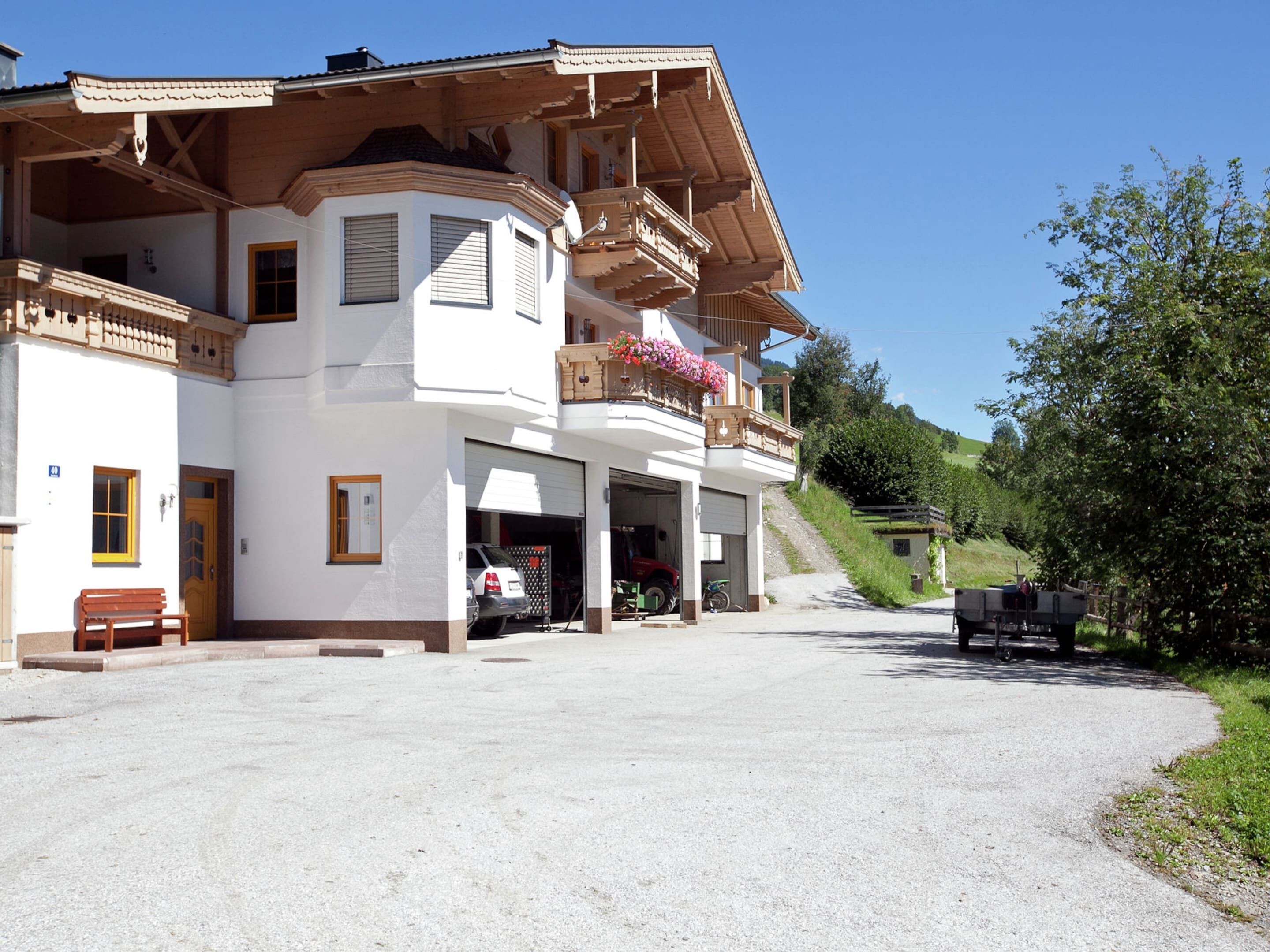 Un immeuble de deux étages doté d’un balcon, d’un garage et d’une allée gravillonnée.