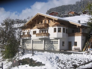 A multi-story chalet with a snow-covered roof, balconies, and a garage. - Stunning Apartment Near Forest in Mittersill (Mittersill)