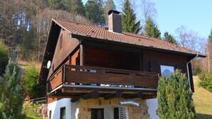 A chalet-style building with a stone facade, wooden balcony, and a sign indicating it is a guesthouse. - Detached Holiday Residence in the Wonderfully Beautiful Harz (Osterode am Harz)