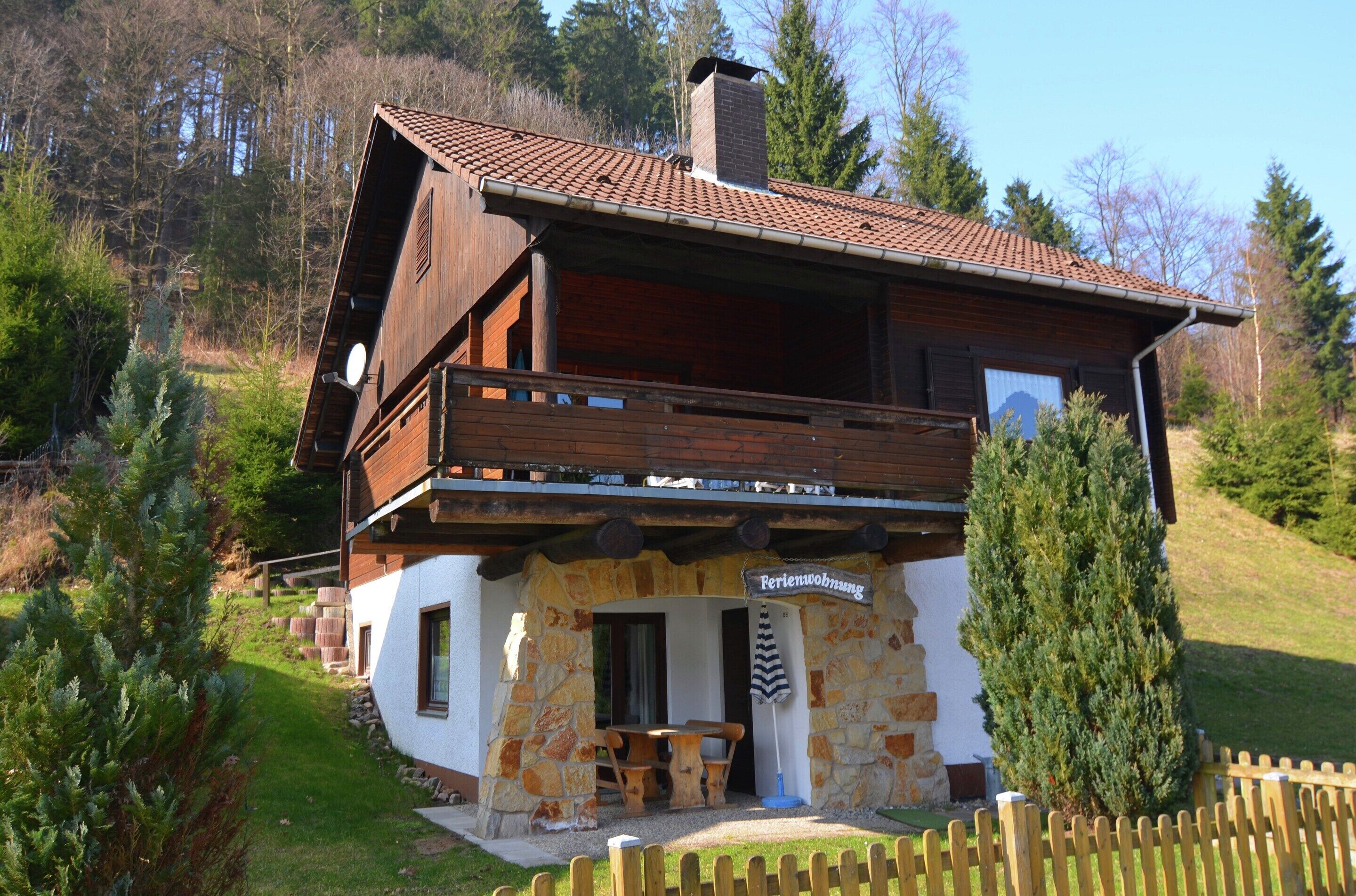 Eine Chalet mit Steinaußenwand, Holzbalkon und einem Schild, das ein Restaurant anzeigt.