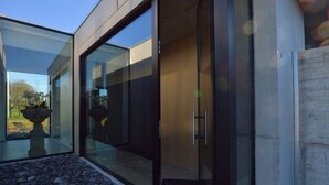 Een modern gebouw met grote glazen deuren en een gastvrij bord.