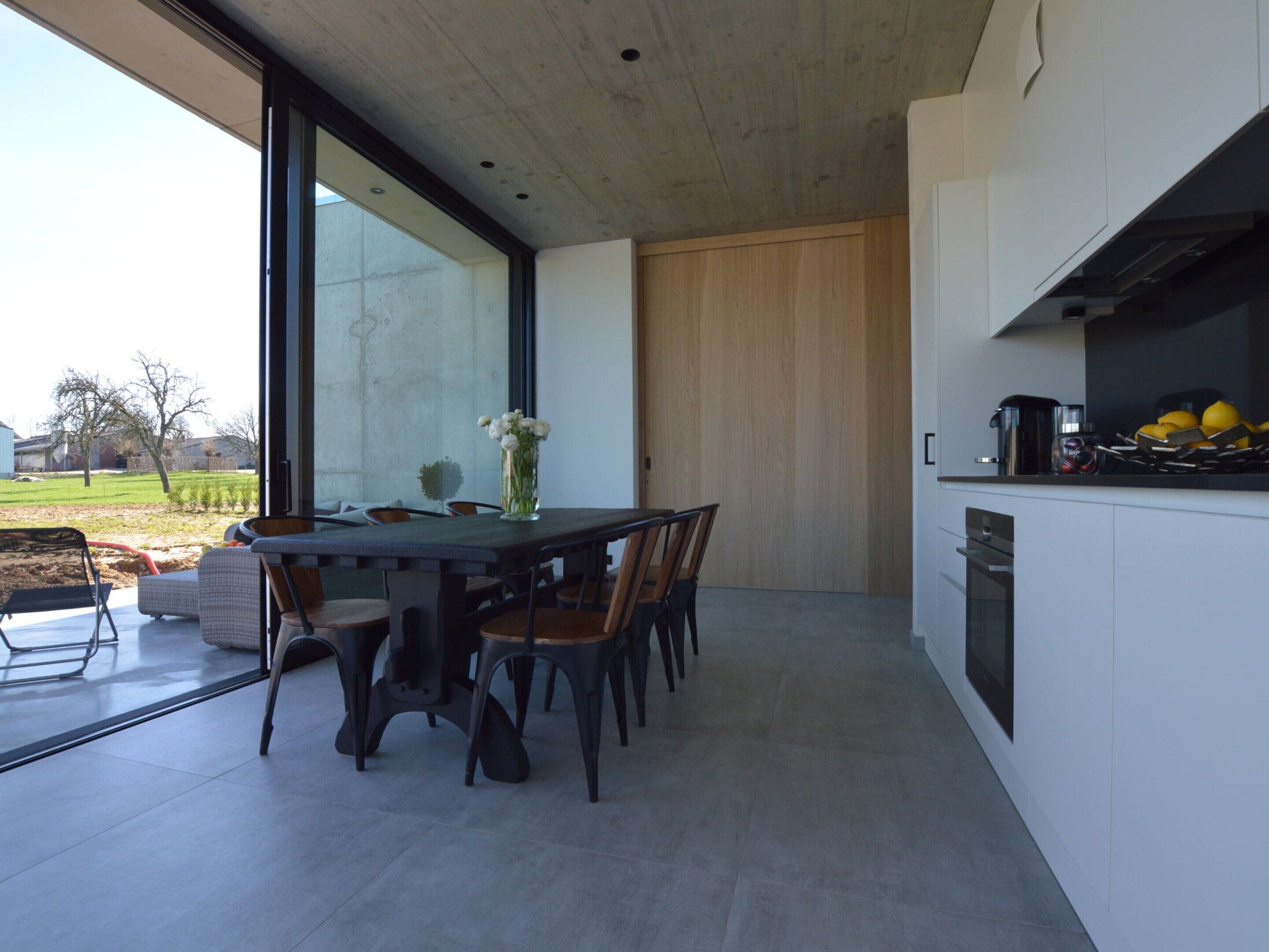 Una cocina moderna con comedor, ventanas amplias y vistas al exterior.