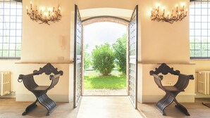 Une porte ouverte donnant sur un jardin, d’où l’on peut admirer la verdure.