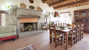 A rustic interior with a stone fireplace, wooden dining table, and chairs. - Farmhouse in Apecchio With Swimming Pool, Terrace, Garden (Apecchio)