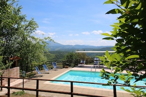 A pool area with a view of mountains, surrounded by greenery and a wooden fence. - Farmhouse in Apecchio With Swimming Pool, Terrace, Garden (Apecchio)