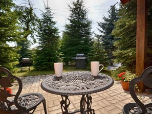Relax in a serene outdoor space surrounded by lush greenery and enjoy a meal at the patio table.