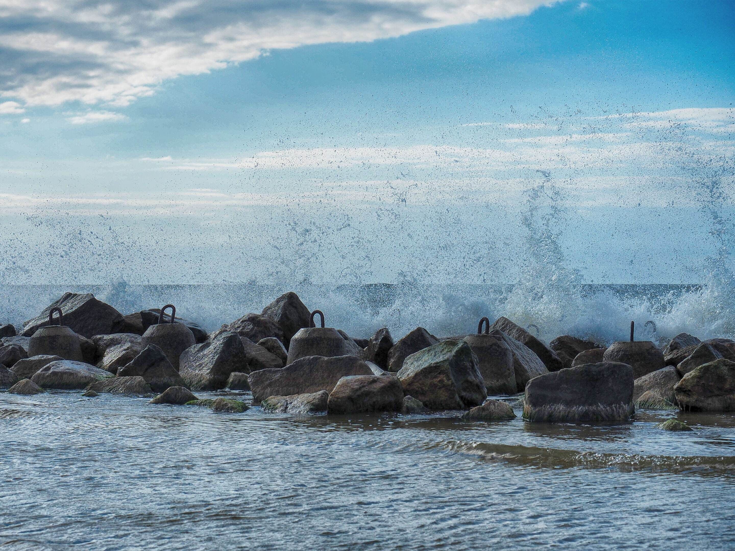 Una costa rocosa con olas rompiendo contra grandes rocas.