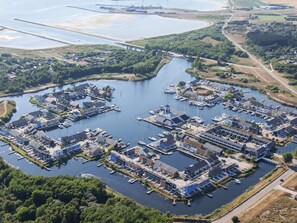 An aerial view of a marina with boats docked, surrounded by greenery and residential buildings. - Holiday Home on a Holiday Park in Ebeltoft (Ebeltoft)