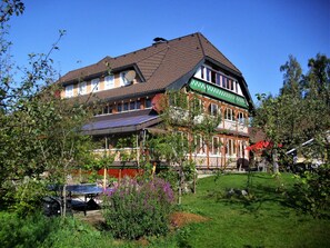 A traditional building with a sloped roof, multiple windows, and a balcony. - Beautiful Apartment in a Black Forest House With Conservatory (Bernau)