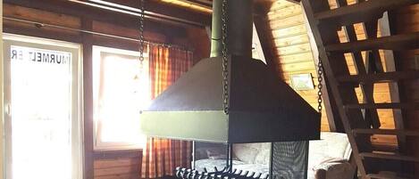 A stone-tiled floor, a large chimney, and a wooden ladder.