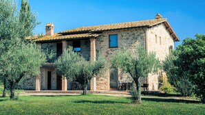 A stone building with a tiled roof, surrounded by olive trees and a grassy lawn. - Pleasant Apartment in Santa Maria Degli Angeli With Pool (Assisi)