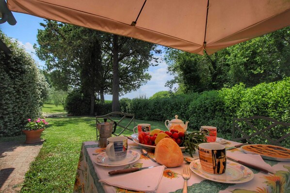 An outdoor dining setup with a table set for a meal, including plates, cups, and a bread roll. - Cosy Farmhouse in Proceno With Swimming Pool (Proceno)