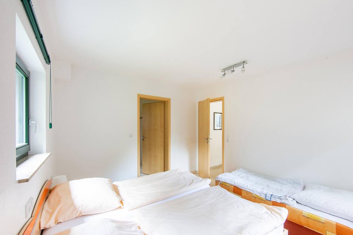 Camera da letto con due letti, una finestra e una porta.