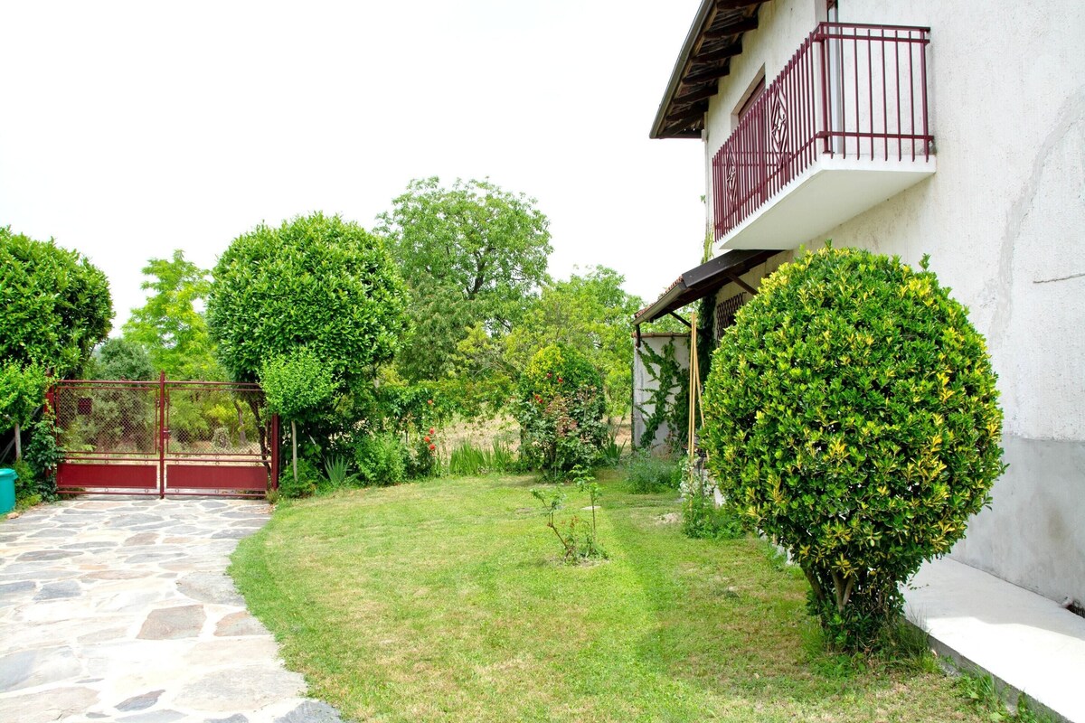 Un sentiero in pietra conduce a un edificio bianco con un balcone rosso.
