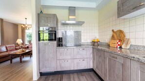Una cocina moderna con armarios de madera, encimera de granito y horno empotrado.