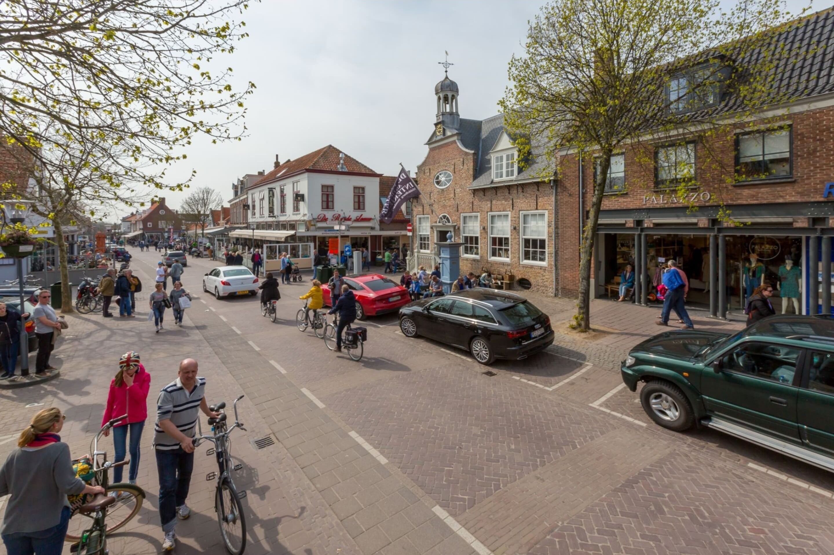 Une scène de rue avec des piétons, des vélos et des voitures.