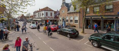 Une scène de rue avec des piétons, des vélos et des voitures.