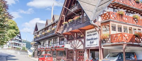 A traditional wooden building with a sign for a restaurant and hotel cafe.
