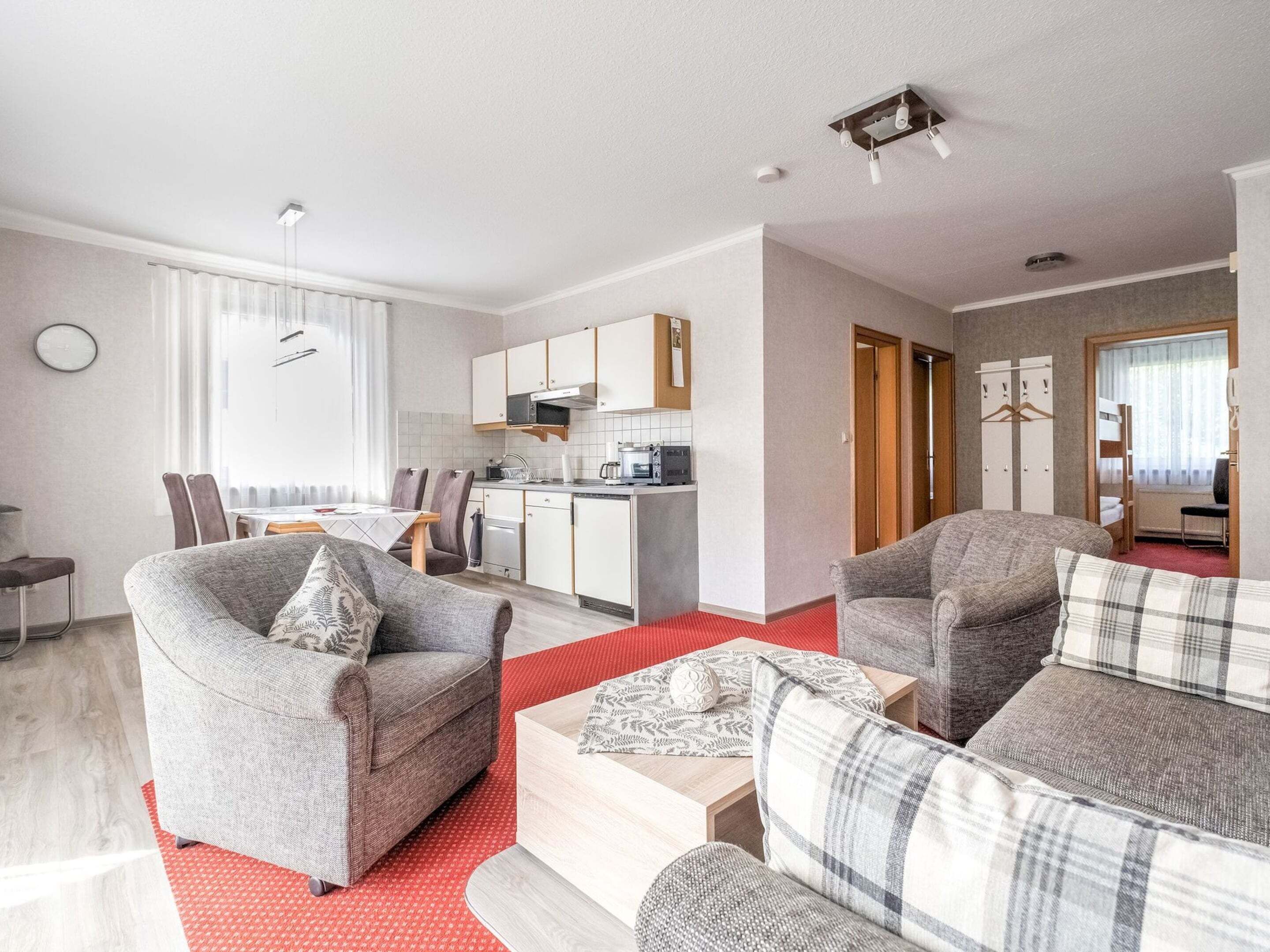 Un appartement moderne comprenant un salon, une cuisine et un petit coin repas.