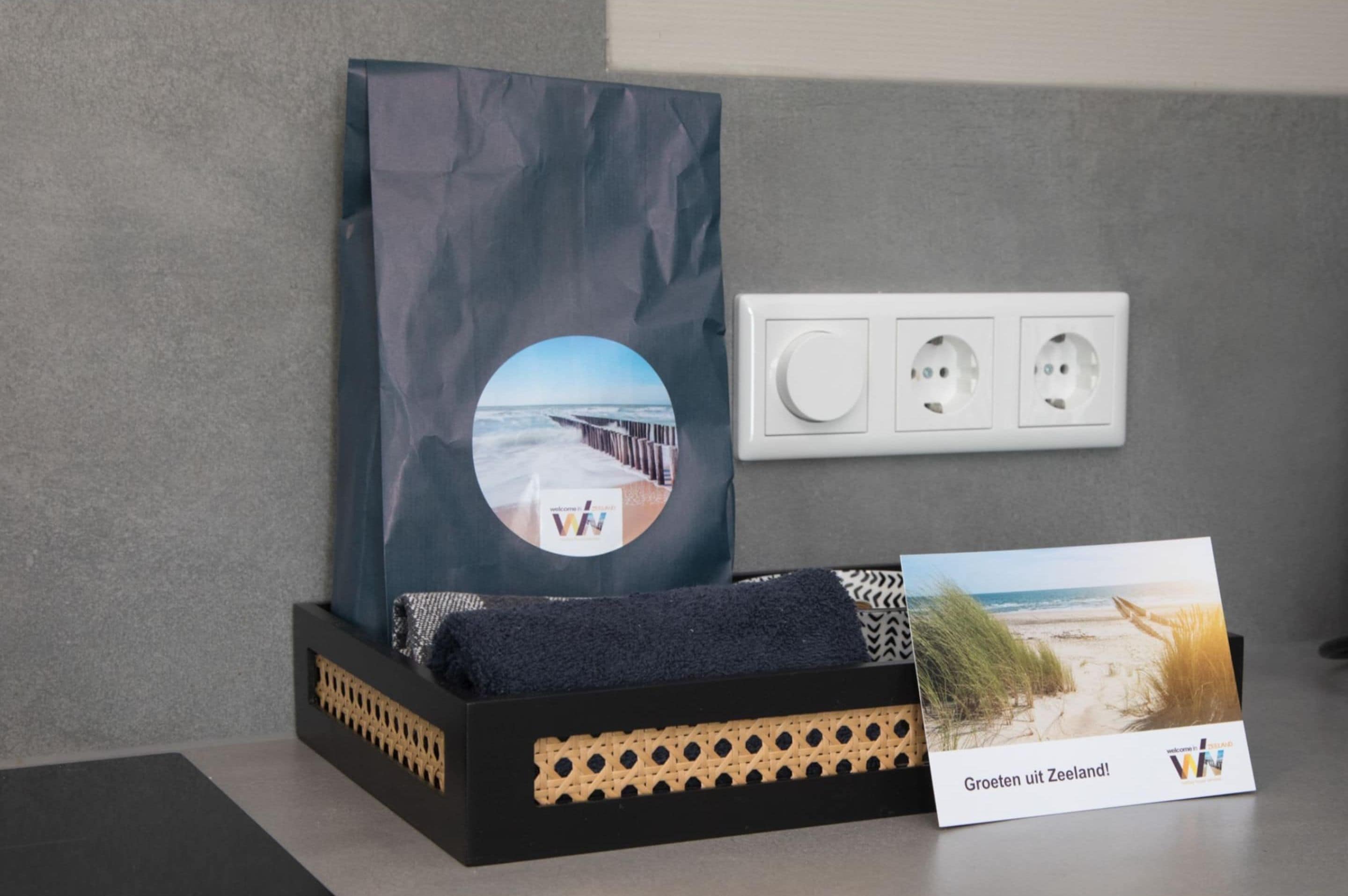 A black box with a cushion, a framed picture, and a card on a table.