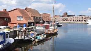 A harbor with boats docked, a building with a red roof, and a clear sky. - Comfortable Apartment Near Insel Poel (Blowatz)