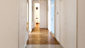 A hallway with white doors, a wooden floor, and a light fixture. - Airy and Sunny Apartment in the Centre of Krakow (Kraków)