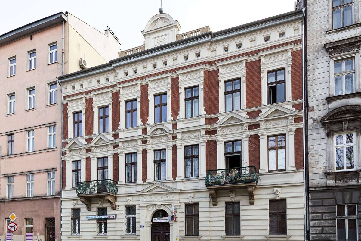 A historic building with a symmetrical facade, large windows, and decorative elements.