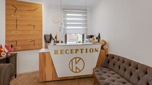 A reception desk with a sign reading "RECEPTION" and a wall clock displaying times for various cities. - Pleasant Apartment in Oberhausen With a Terrace (Oberhausen)