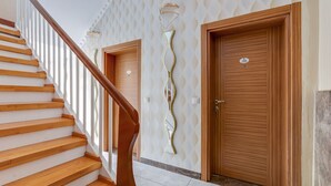 A staircase with wooden steps and a wooden handrail, leading to a door with a number plate. - Pleasant Apartment in Oberhausen With a Terrace (Oberhausen)