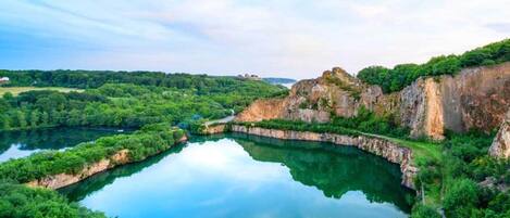 Un lago tranquilo rodeado de exuberante vegetación y escarpados riscos.