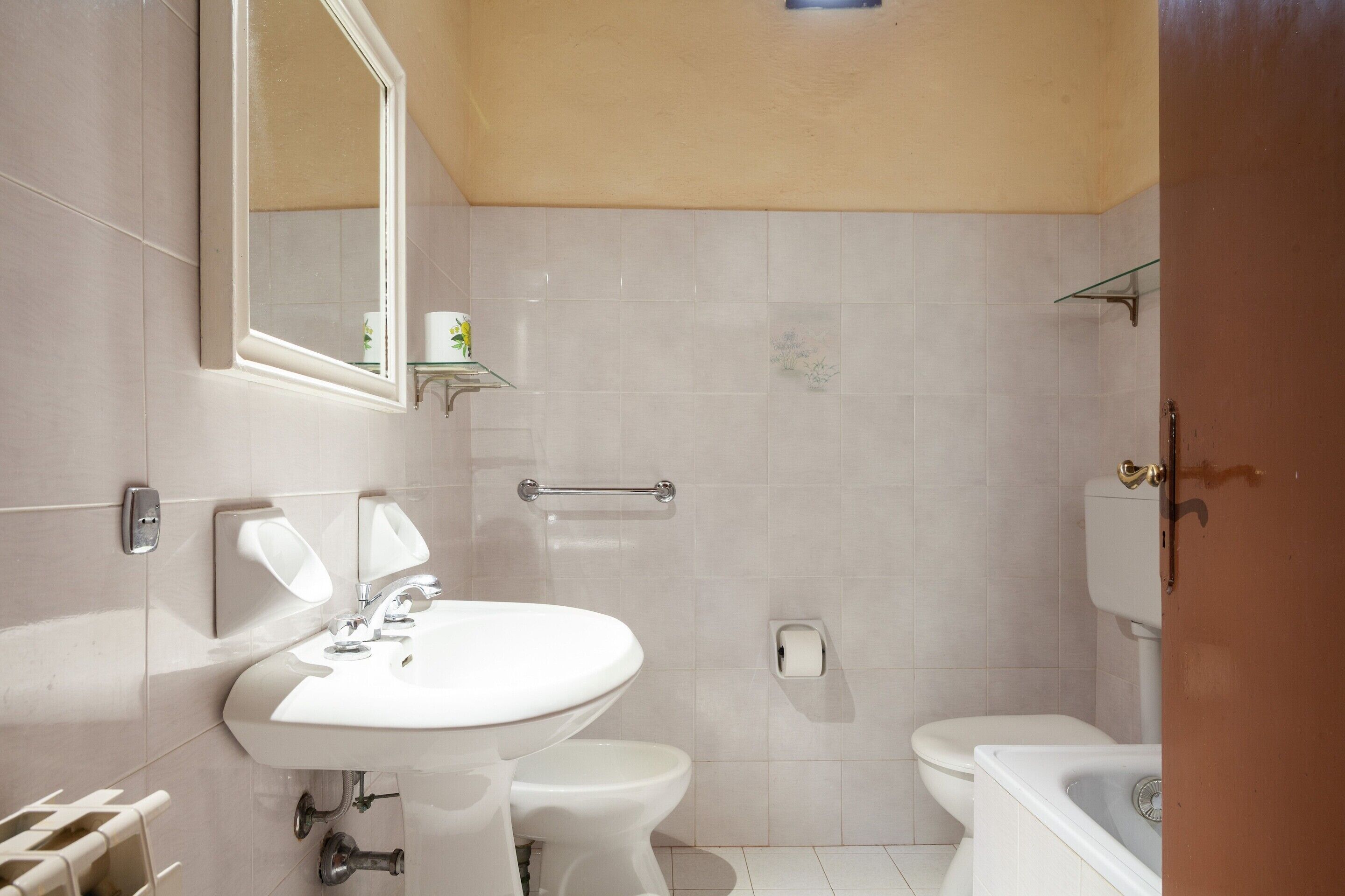 Et badeværelse med vask, toilet og badekar.