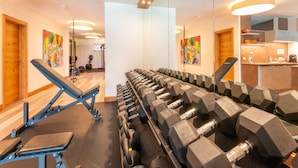 A gym with exercise equipment, a bench, and dumbbells. - Premium Apartments im Zillertal (Hart im Zillertal)