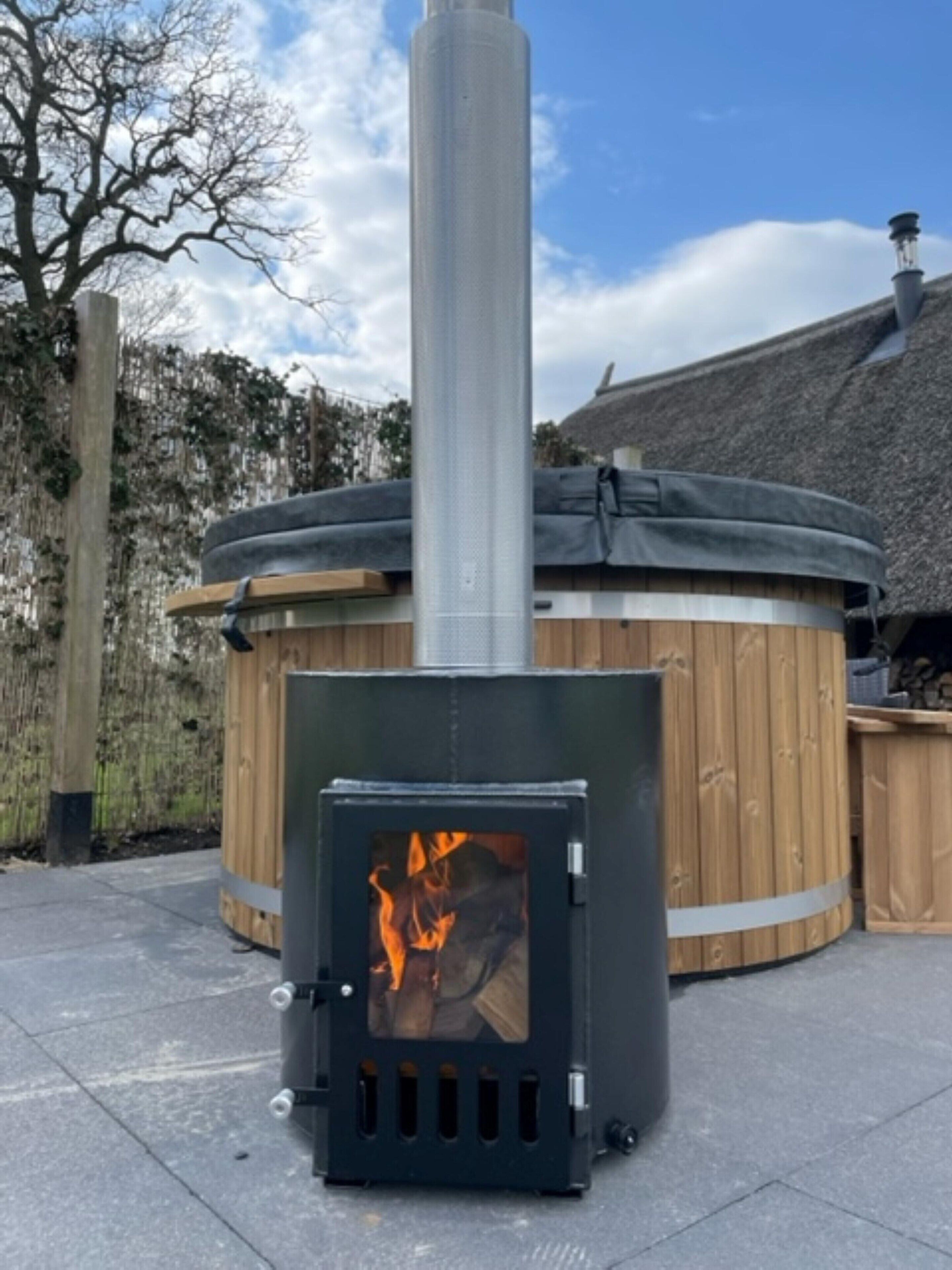 A wood-burning stove with visible flames, a wooden structure with a thatched roof, and a clear sky in the background.