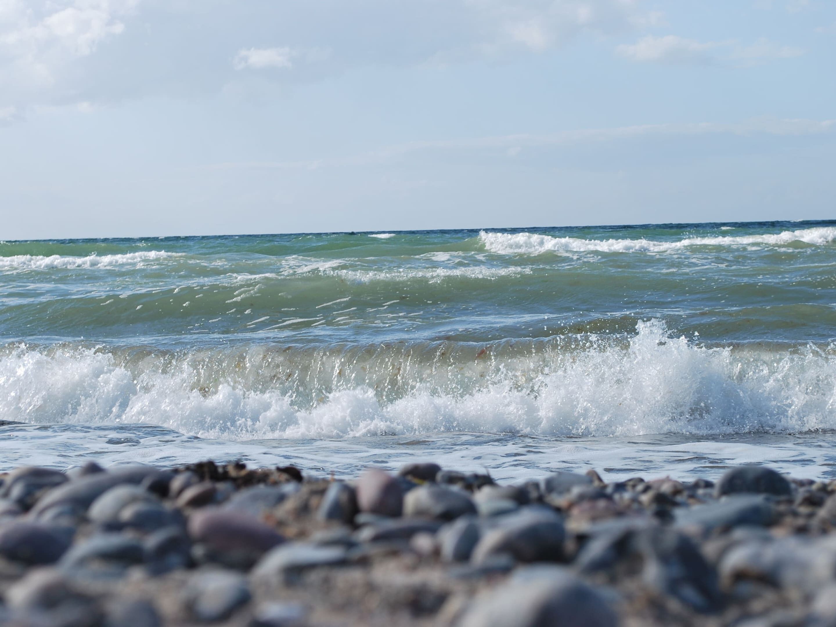 A rocky shoreline with waves crashing onto the beach.