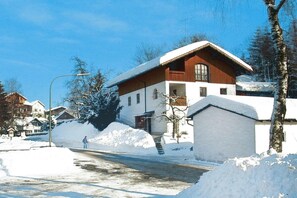 A snow-covered building with a wooden facade and a balcony, surrounded by snowbanks and trees. - Comfortable Apartment in Zenting in Lower Bavaria (Zenting)