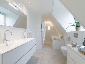 A modern bathroom with a large vanity, a bathtub, and a toilet. - Luxury 8-person Wellness Villa With Sauna and Outdoor hot tub is Unique (Colijnsplaat)
