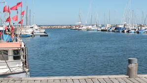 A marina with multiple boats docked, a wooden pier, and a clear sky. - Landhauswohnung in Kroepelin mit Grossem Garten (Kroepelin)