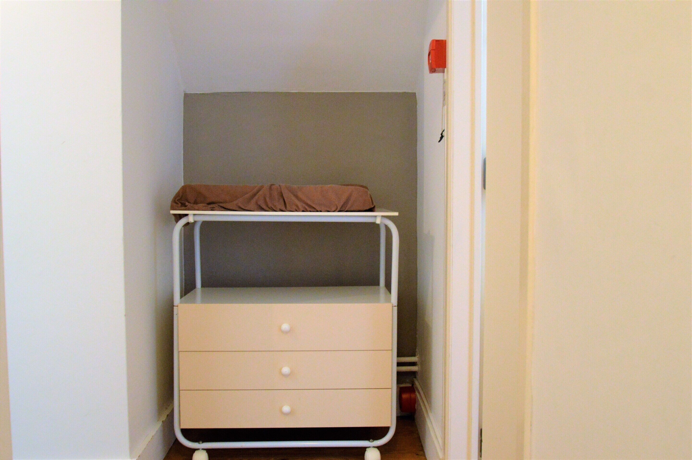 A small, compact room with a bunk bed and a single drawer unit.