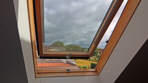 A skylight with a view of a residential area, including houses and trees. - Tasteful Apartment in Rerik Germany With Garden (Rerik)