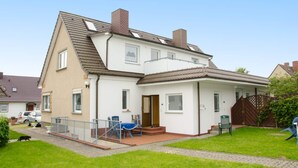 A two-story residential house with a sloped roof, a front porch, and a small garden area. - Tasteful Apartment in Rerik Germany With Garden (Rerik)