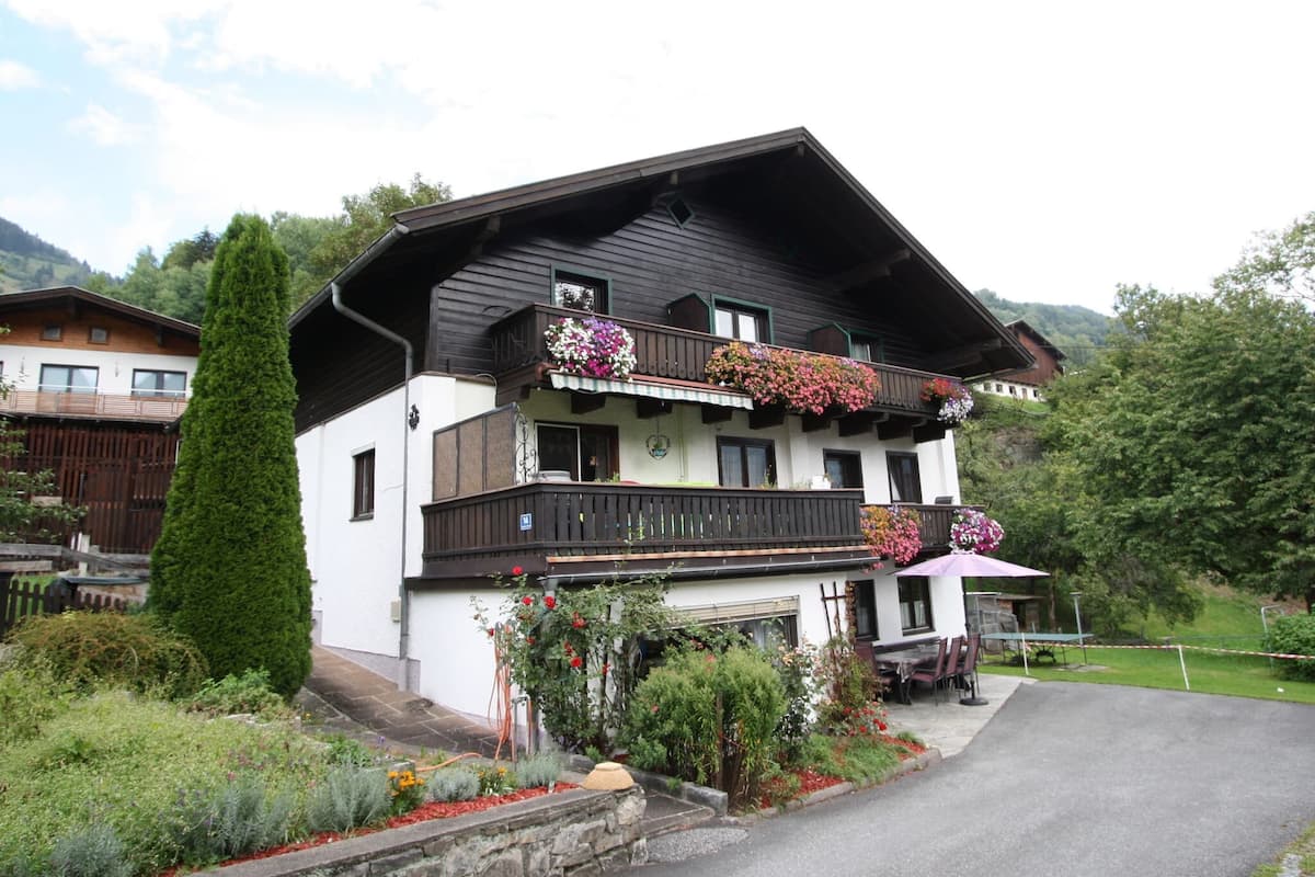A two-story building with a balcony adorned with colorful flowers.