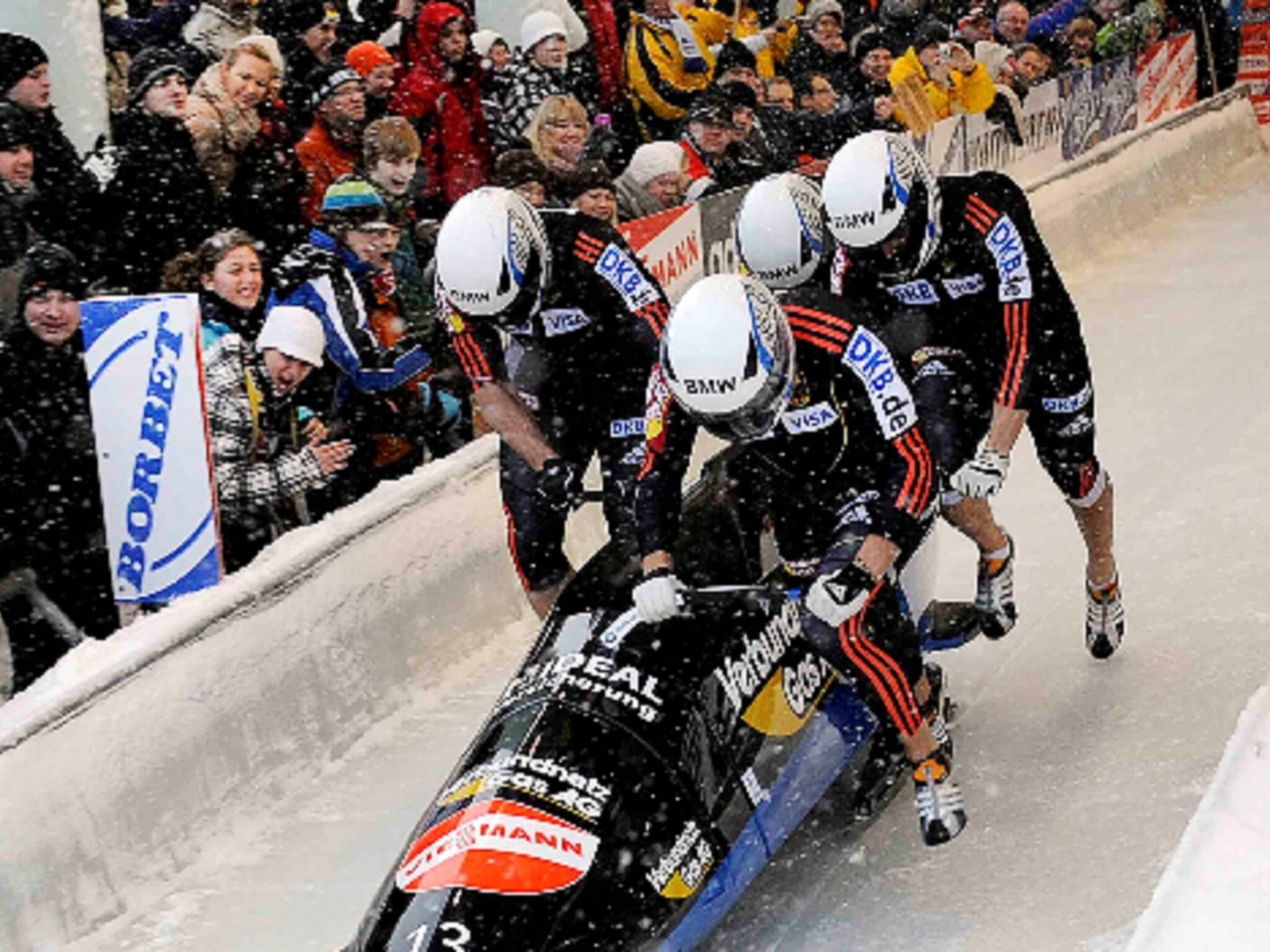 Una corsa motociclistica con piloti in tute bianche e nere, caschi e loghi degli sponsor.