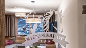A dining area with a wooden table, chairs, and a view of the outdoors. - Farmhouse in Schwendau With Ski Storage (Schwendau)
