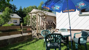 An outdoor seating area with a table and chairs, a wooden structure, and a blue umbrella with the text "MÖVENPICK". - Spacious Holiday Home in Ulmen Near the Centre (Ulmen)