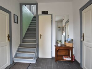 Un escalier menant à un palier où se trouve une porte sur laquelle est inscrit « Bienvenue ».