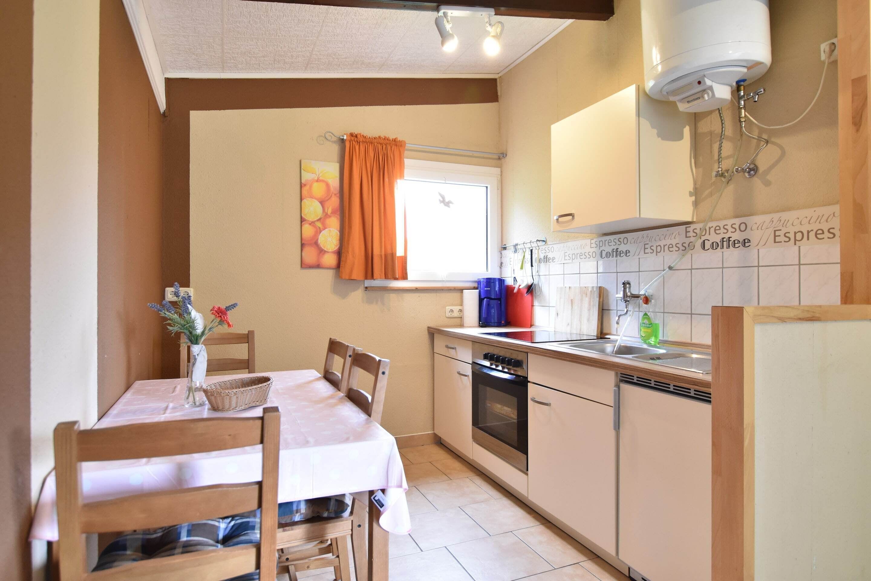 Een keuken met een eettafel, stoelen, een fornuis en een koffieapparaat.