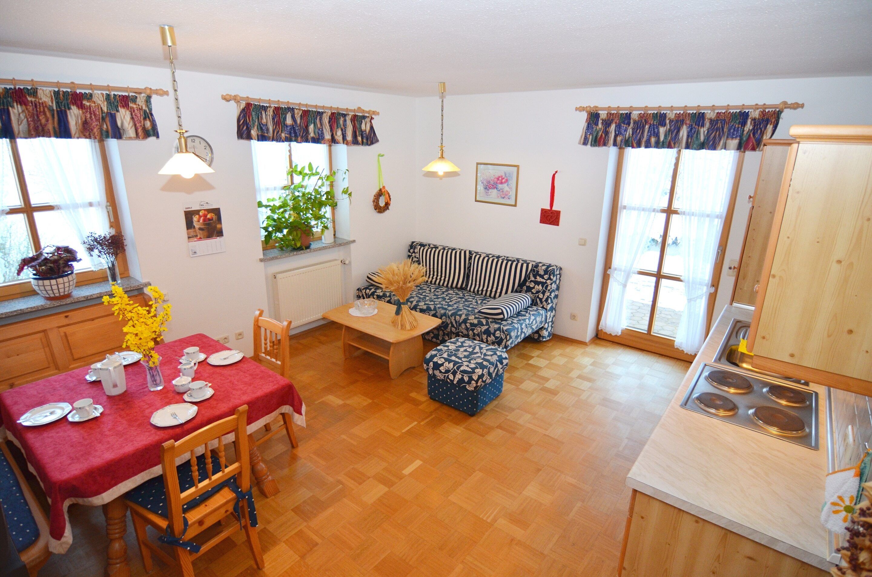 Una cocina acogedora con una mesa de comedor, sillas, un sofá y una estufa.