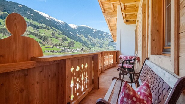 A wooden balcony with a bench and table, overlooking a mountainous landscape. - Apartment With Panoramic View (Ramsau im Zillertal)