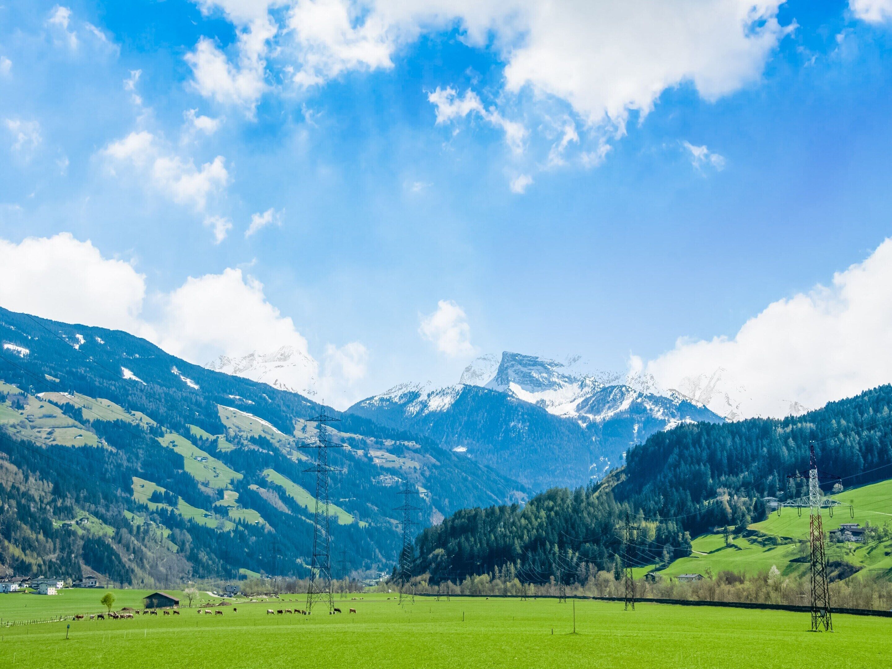 A mountainous landscape with green fields and a clear sky.