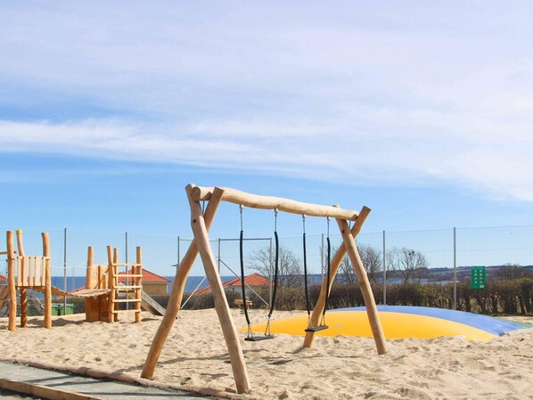 A wooden swing set in a sandy playground area with a clear sky. - 6 Person Holiday Home in Allinge (Gudhjem)